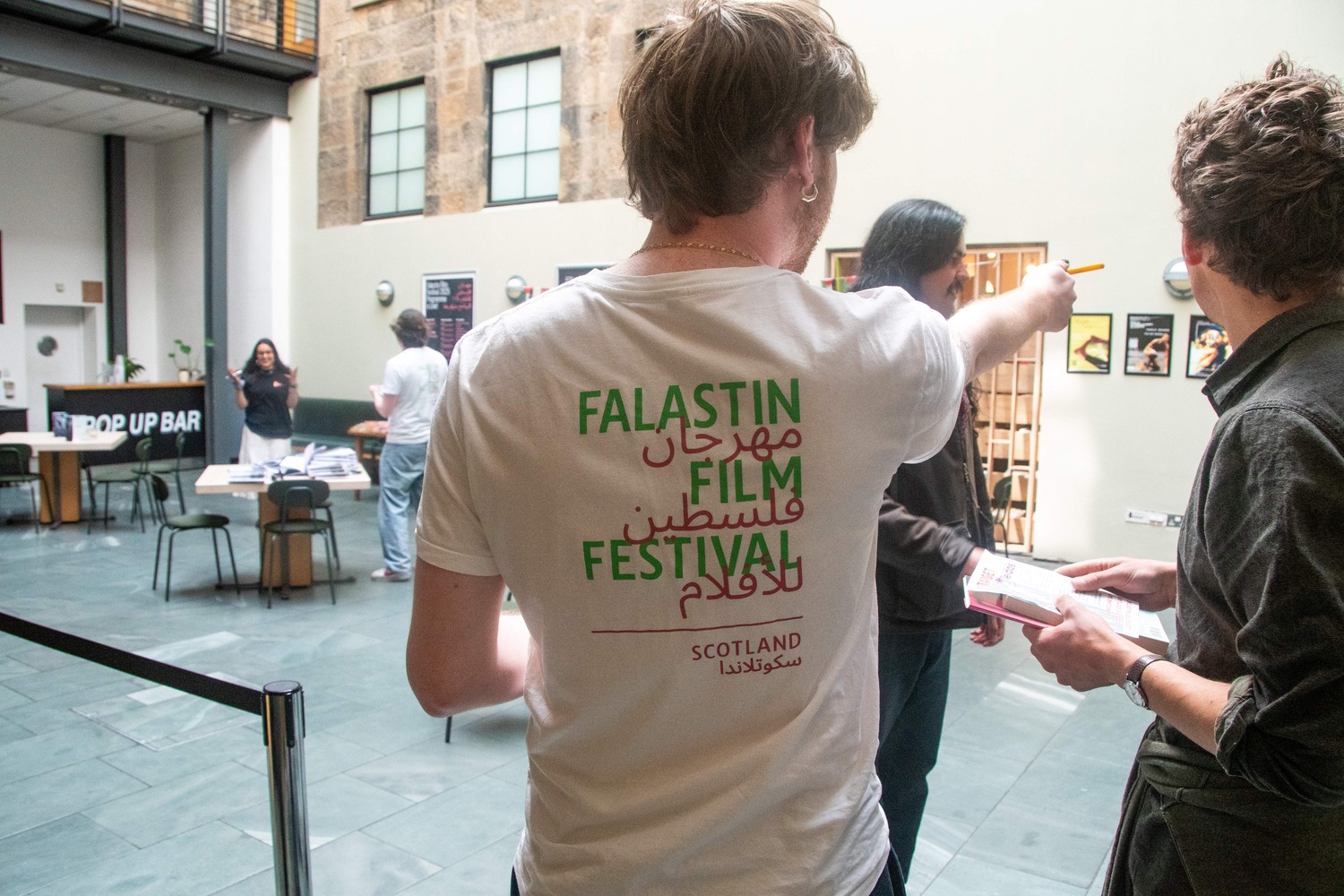 A member of the SSG team taking tickets at the door of a screening at the Glasgow edition of Falastin Film Festival 2025 that we helped run at the CCA.