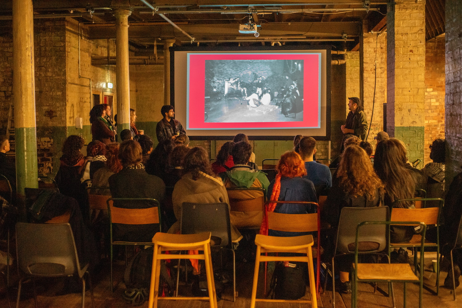The SSG Team & Rupture cinema giving a presentation at our 'Solidarity is something you can hold in your hands' screening, while the audince watches