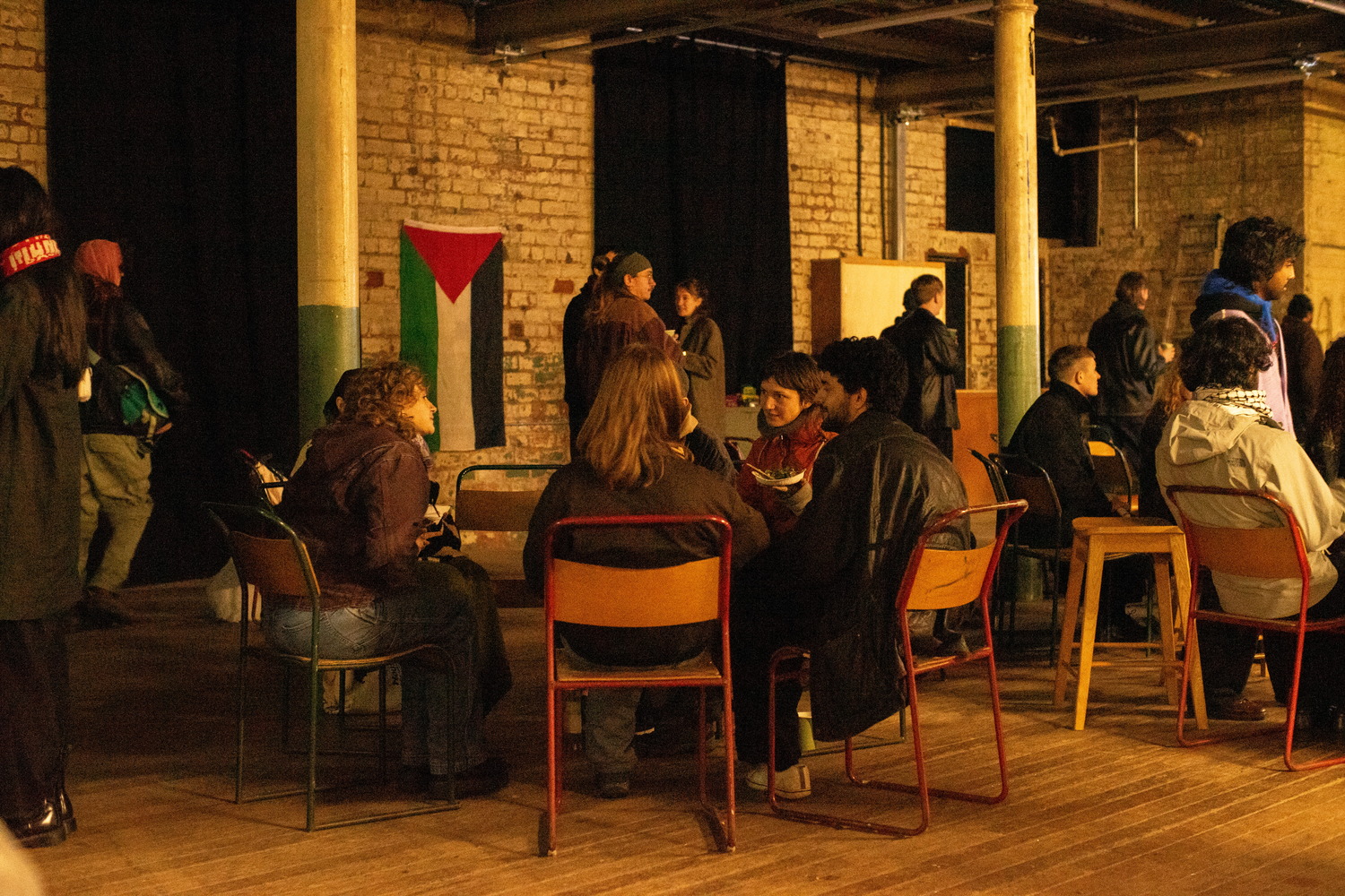 The breakout discussion groups had at the 'Solidarity is something you can hold in your hands' screening. People are discussing while they eat, while some others queue for food.