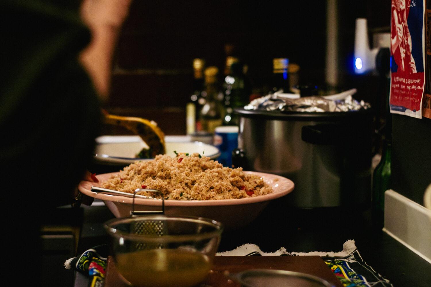 A close up of rice and salad being placed into their serving bowls in the Listen Gallery kitchen.