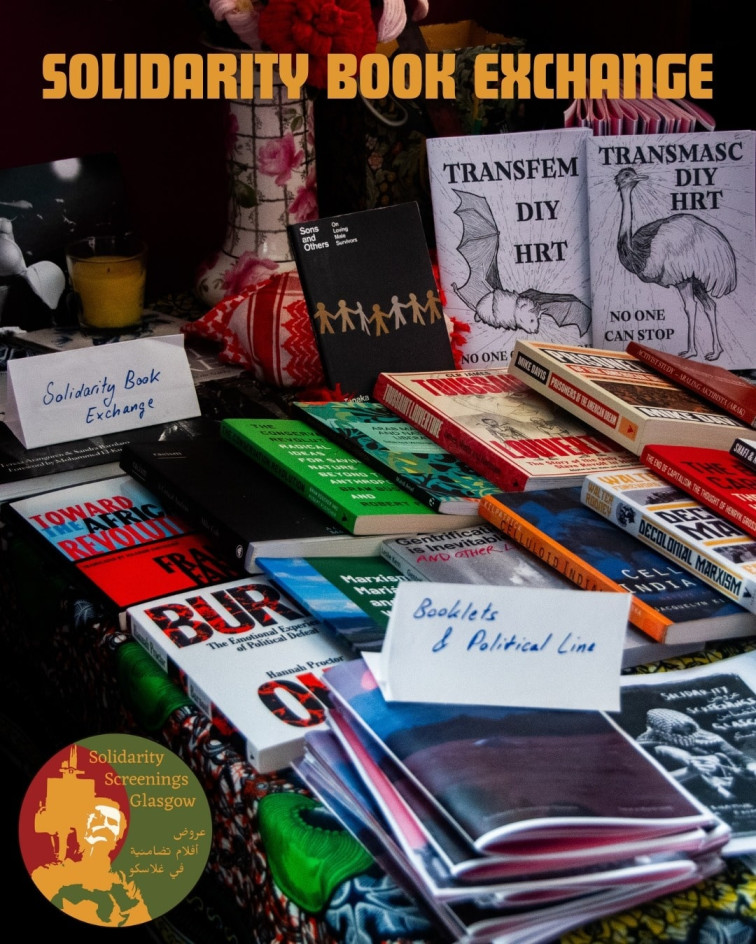 The Solidarity Book Exchange is set up on a table. There is a title of 'Solidarity Book Exchange' and the Solidarity Screenings logo in the bottom right corner
